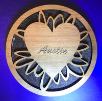 four inch round wooden beverage coaster with artistic ovals connecting a heart shape centre with laser engraved text to an outer ring.