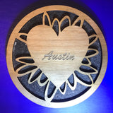 four inch round wooden beverage coaster with artistic ovals connecting a heart shape centre with laser engraved text to an outer ring.